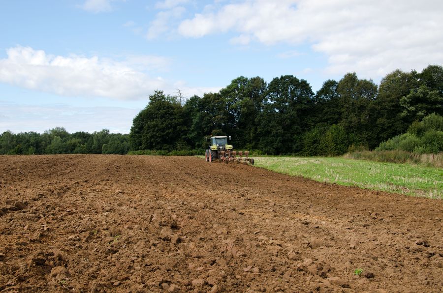 tractor plowing agricultural field summer